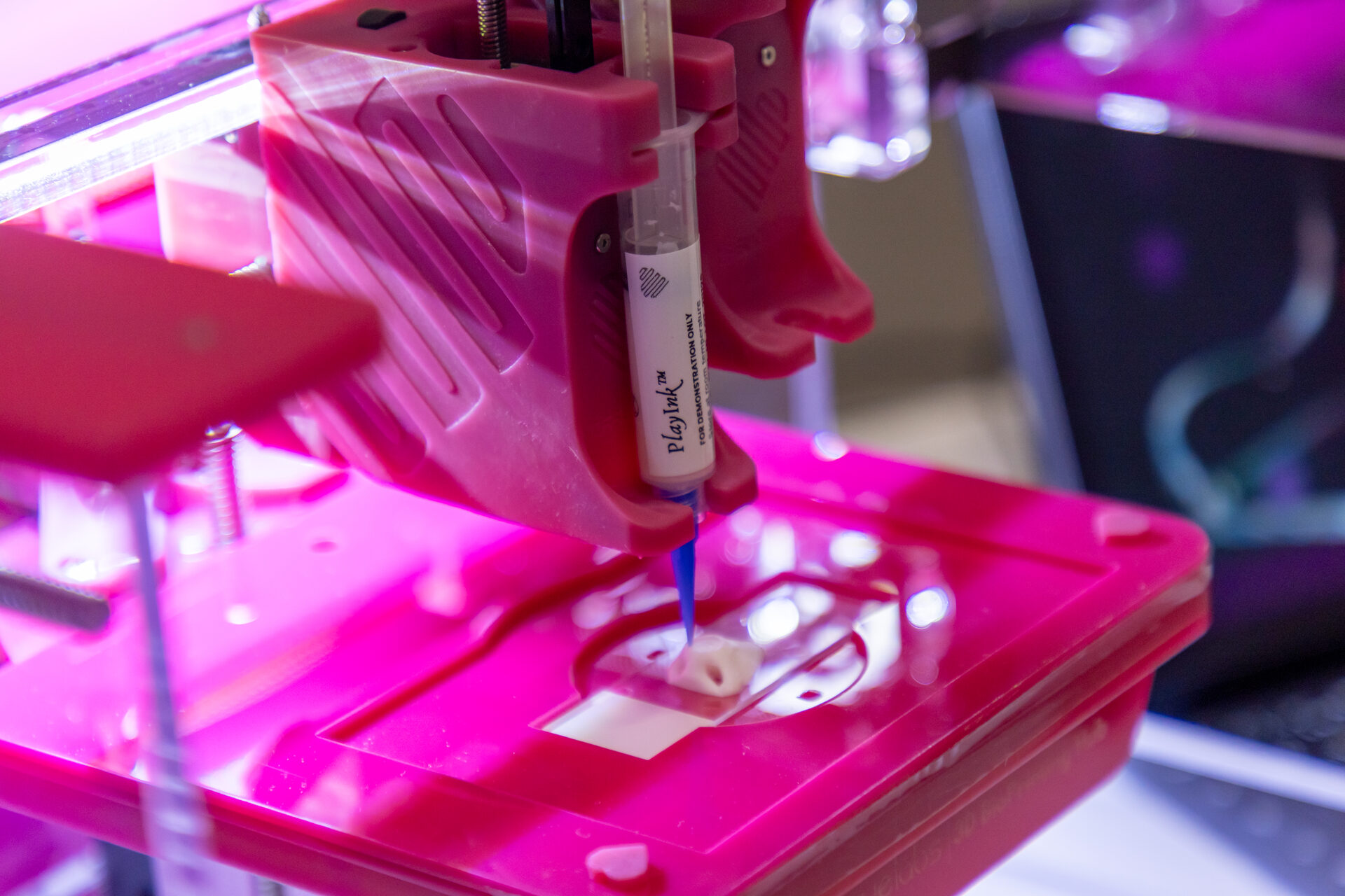 Detalhe da bioimpressora 3D com a seringa de biotinta TissueFab posicionada sobre a placa de cultivo
